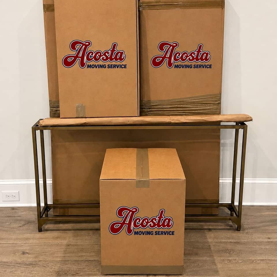 Acosta Moving Service branded boxes packed and stacked on a console table in a client's home